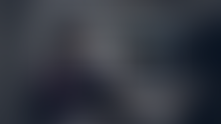 Optometrist reviewing OCT eye scan at an optician, with retinal imaging displayed on screen