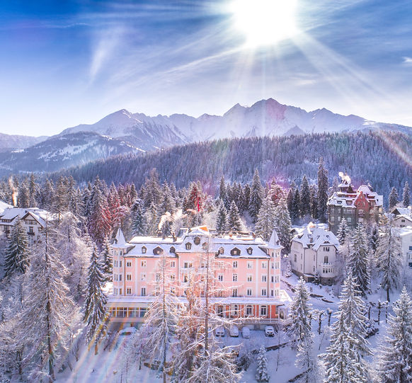 1_Schweizerhof-Flims-Waldhaus-Hotel-Winteransicht-verschneit-Sonne-2018-basichomeproductio