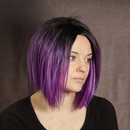 Eine Frau trägt eine violett lila Perücke mit einem kurzen Bob Haarschnitt mit schwarzem Ansatz und Seitenscheitel, Perücke zum kaufen, Perücken in Rostock, Perücken Norddeutschland
