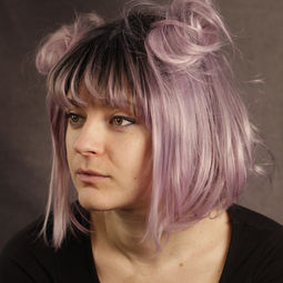 Eine Frau trägt eine Rosa-Flieder Perücke mit einem kurzen Bob Haarschnitt mit schwarzem Ansatz und Pony und Spacebun Frisur, Perücke zum kaufen, Perücken in Rostock, Perücken Norddeutschland