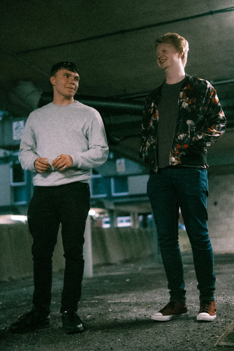 two men chatting in car park
