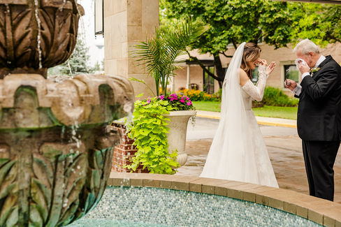 father daughter first look in front of the drake in oak brook next to the fountain