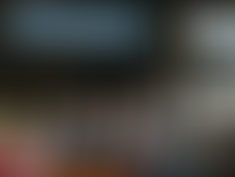 Four people in black shirts stand under a blue "The Ocala Design Group" banner in an indoor rodeo setting, smiling confidently.