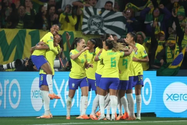 Jogadoras da seleção feminina celebram e se abraçam.