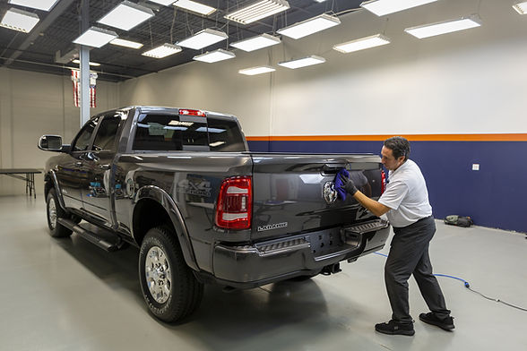 Applying a professional-grade Gyeon ceramic coating to the door of a Ram 2500 truck, ensuring long-lasting, durable protection for a large vehicle.