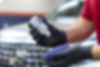 A near shot of Gyeon Professional Ceramic Coating being precisely poured onto an applicator before being applied to the 2022 Lexus LX 460 in the background.