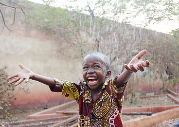Sweet little African boy under the rain