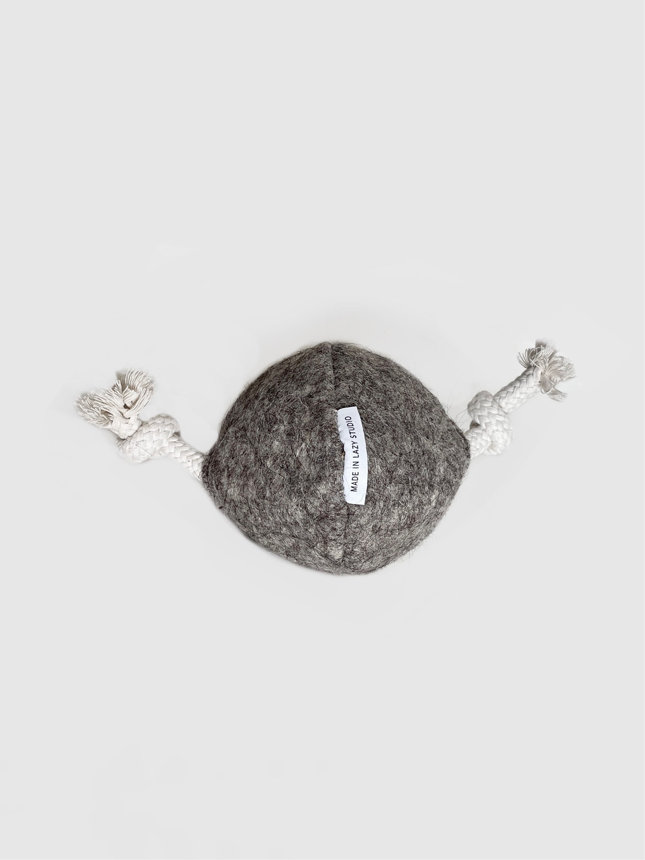 Szara piłka z metką, z napisem logo, na sznurkach, na białym tle. skórzana obroża dla psa