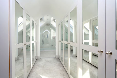 A large modern bathroom with tiled floor, walk-in-shower, marble countertop sink has been installed in a large loft conversion.