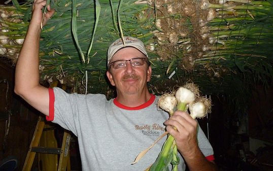 Owner of Dusty Garlic Spices holding garlic.
