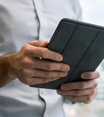 image of man in blue shirt looking at tablet_CLOSE UP.webp