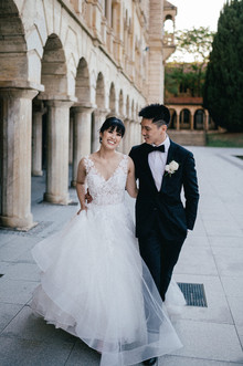 A very happy bride and groom taking a walk at UWA