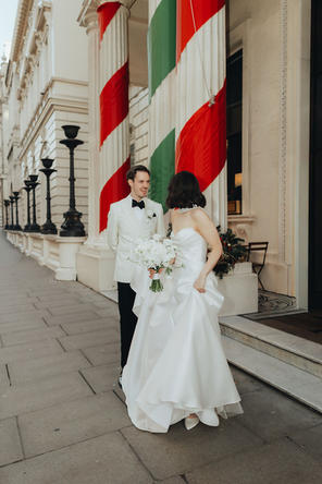 Bride and groom framed by the architecture outside 116 Pall Mall, central London, with soft natural light emphasizing their elegance.