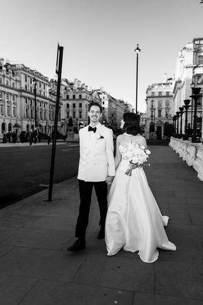 Bride and groom holding hands outside 116 Pall Mall, central London, sharing a calm, intimate moment.