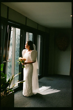 Bride Looking out of window with bouquet Town Hall Hotel London 