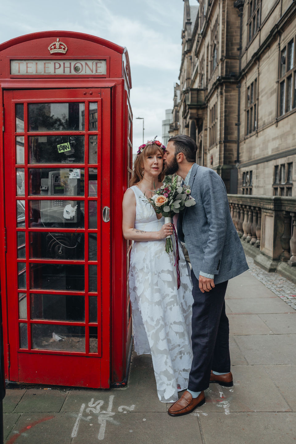 bride and groom portrait in Nottingham next to red phone-box  