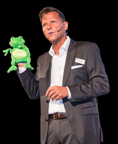 Prof. Däfler hält eine Frosch-Handpuppe hoch
