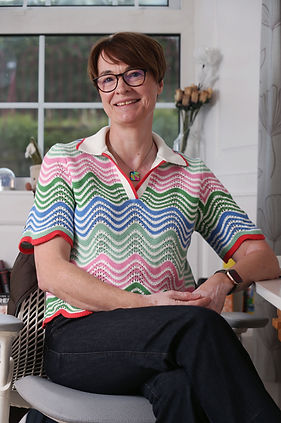 Natalie sitting at her desk, smiling to camera