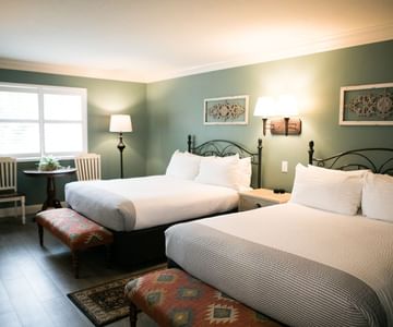 Warm cozy beds blending rustic warmth with timeless charm, the hotel rooms and suites at Cambria Pines Lodge