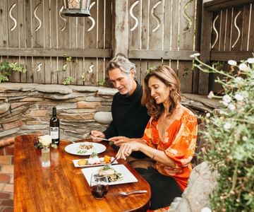 A couple enjoy fresh, regionally-inspired dining and drink. Dine in a relaxing, casual environment with beautiful garden views