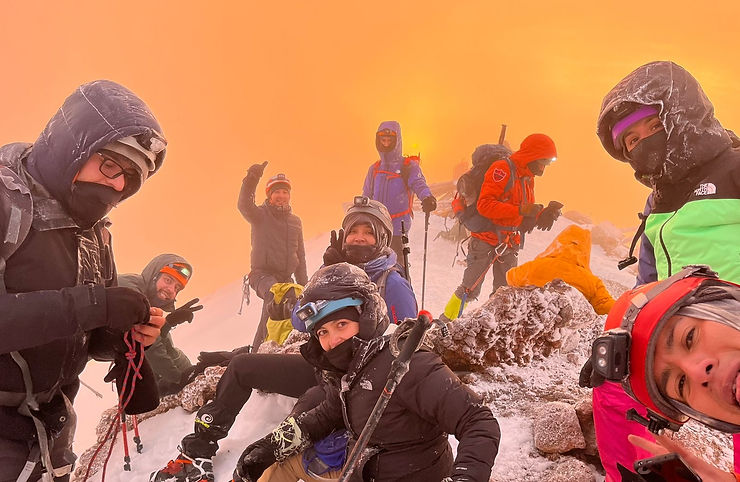 Grupo de montañistas guiados por Libres y Viajeros en la cima del Iztaccíhuatl con vista panorámica de los volcanes de México