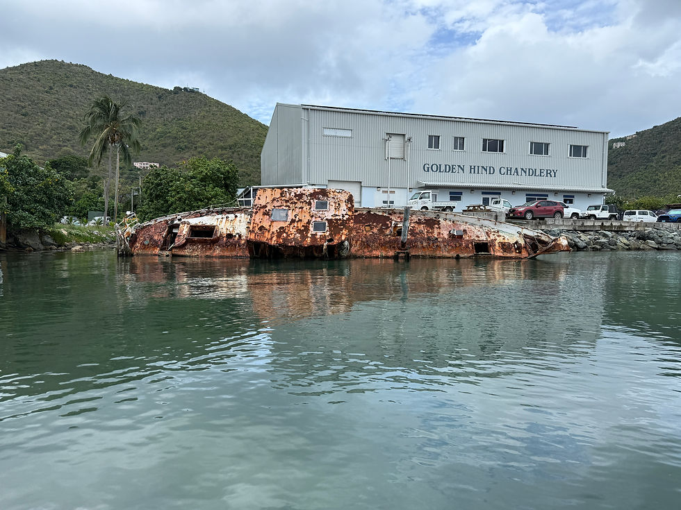 Remaining of a boat rusting and lying on its side at the shore.