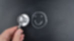 person holds stethoscope near chalk outline smiley face
