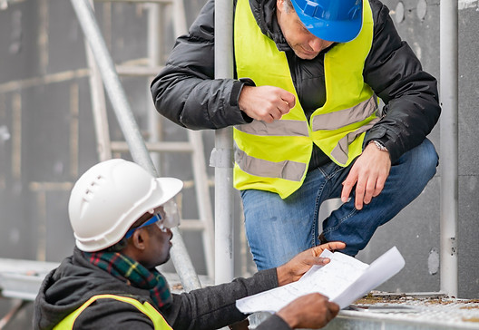 worker-showing-blueprint-while-working-c