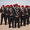 COMPANY OF BLACK AMERICAN MEN IN BLACK GUARD UNIFORM STANDING IN FORMATION WITH RED BERETS