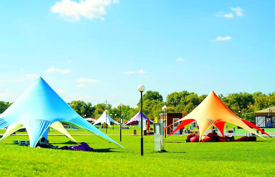 Large open sided camping tents at an event. DJ Golf carts provides transportation and logistic options for these types of events.