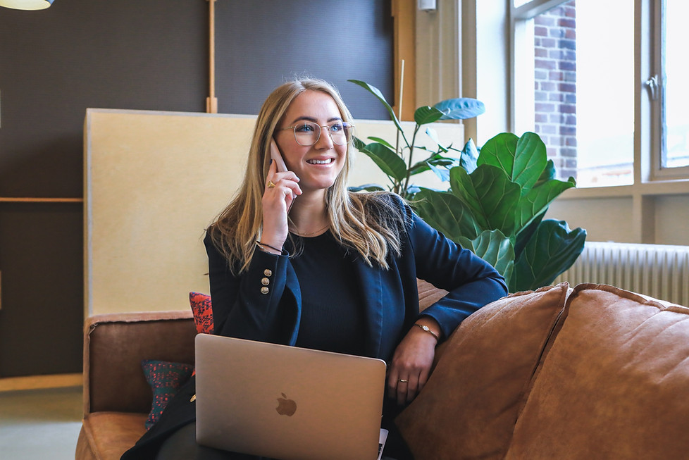 Caucasian woman with blonde hair and glasses on the phone excited