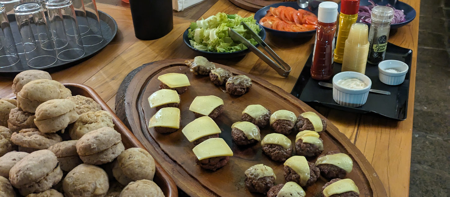 Mesa de buffet com pães de queijo e salgados