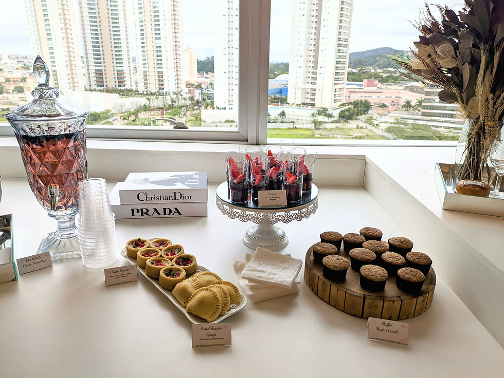 Mesa de festa com doces variados e vista da cidade.