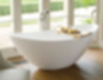 Waters freestanding bath with deep curved double-ended sides.
