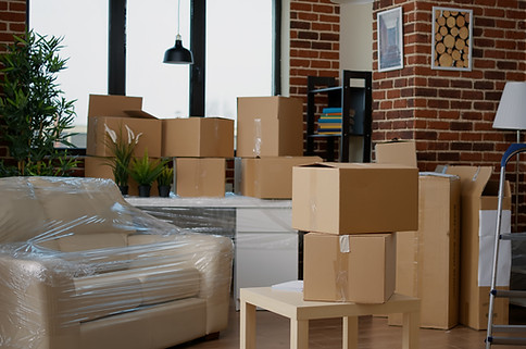 nobody-in-empty-living-room-with-cardboard-packaging-at-new-home-furniture-things-in-stack