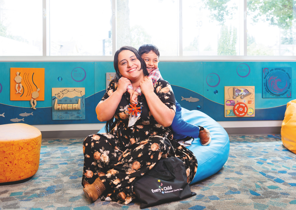 Maryuri and her son, Ishmael, embrace in the Gregory Heights Library children's space.