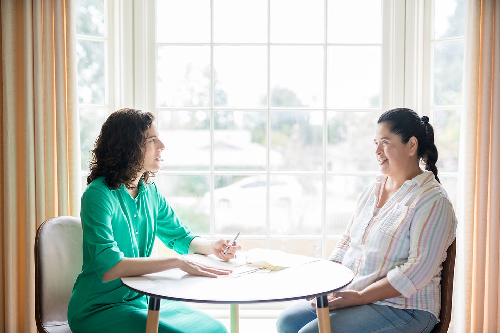 Kendra talking to woman client with a window background