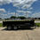 Thumbnail: Gratimax tandem axle dump trailer with black steel frame, hydraulic lift, and integrated tarp system, ideal for construction debris and material transport.