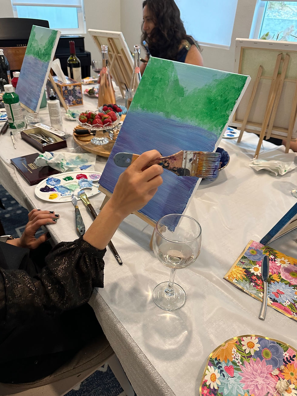 Close-up of hand painting with wine glass on table during girls' night event