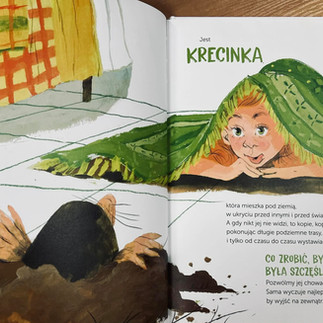 chłopiec ukrywa się pod dywanem