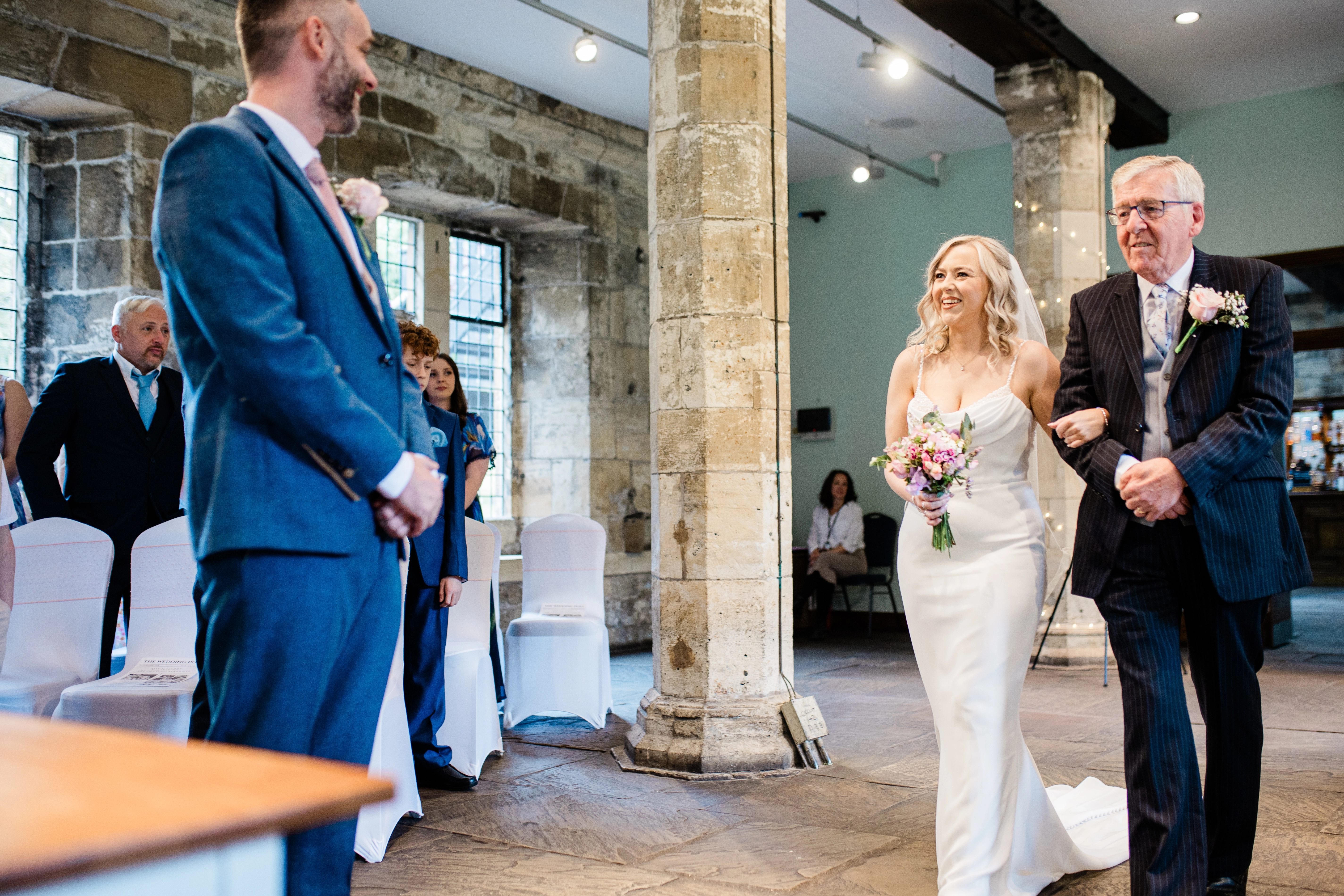 the bride and her father walking down the aisle to greet the groom