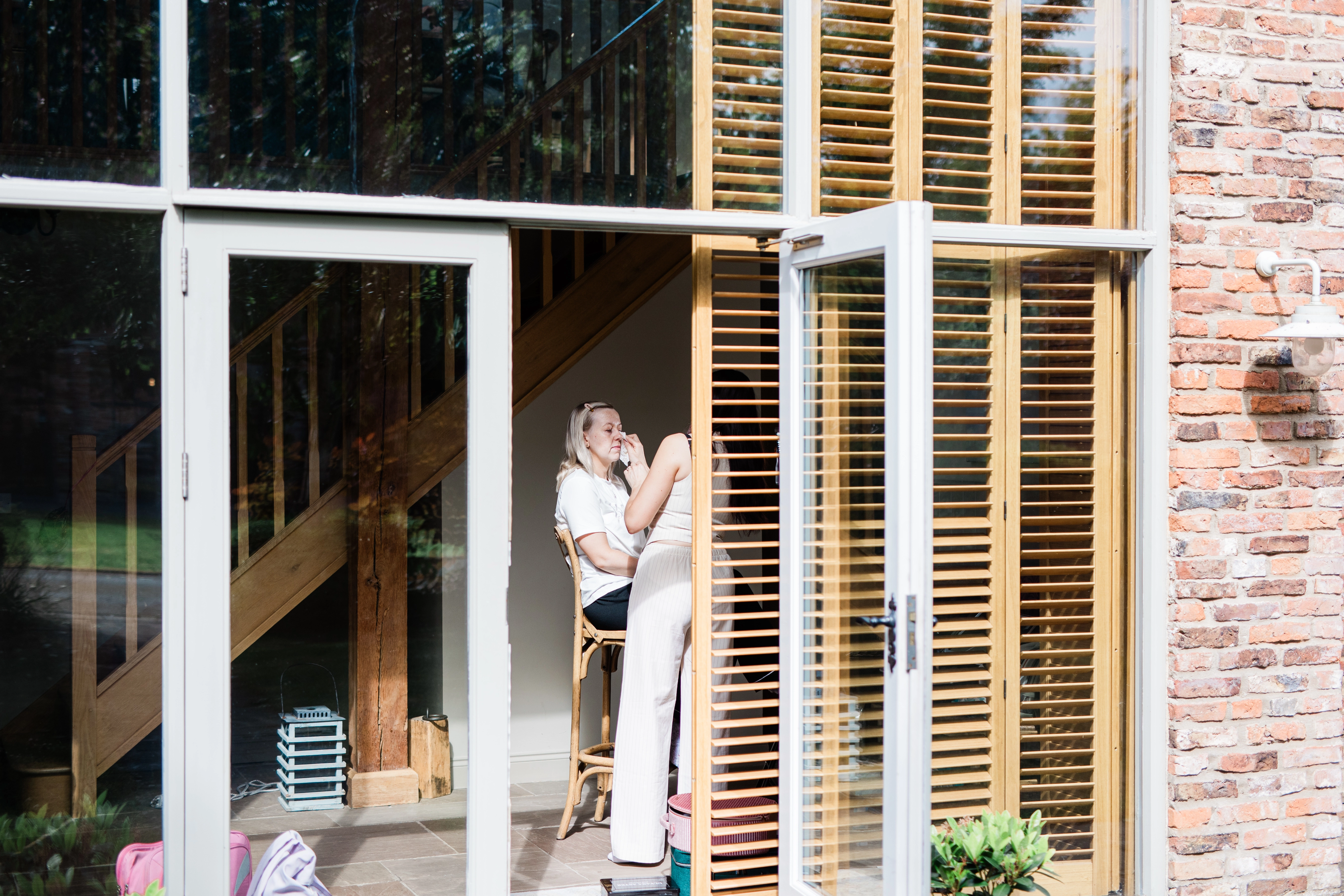 The bride getting her makeup done prior to the wedding