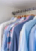 Neatly organized shirts hanging in closet