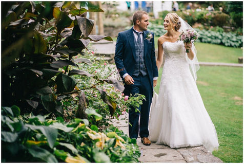 Newlyweds walking through a garden path