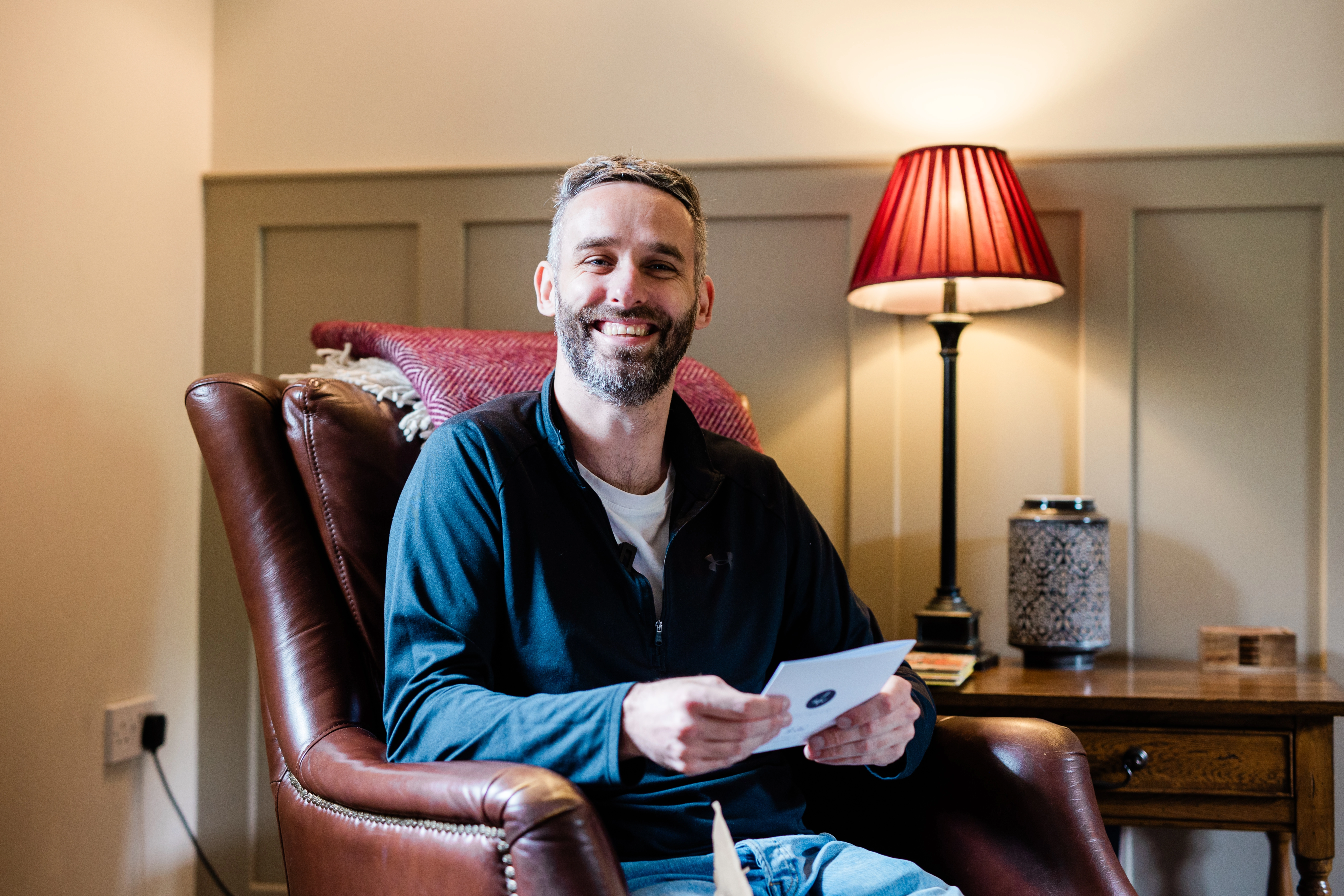 A smiling groom reading his card from the bride