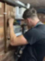 Dylan-working-on-a-fuse-box-in-a-house