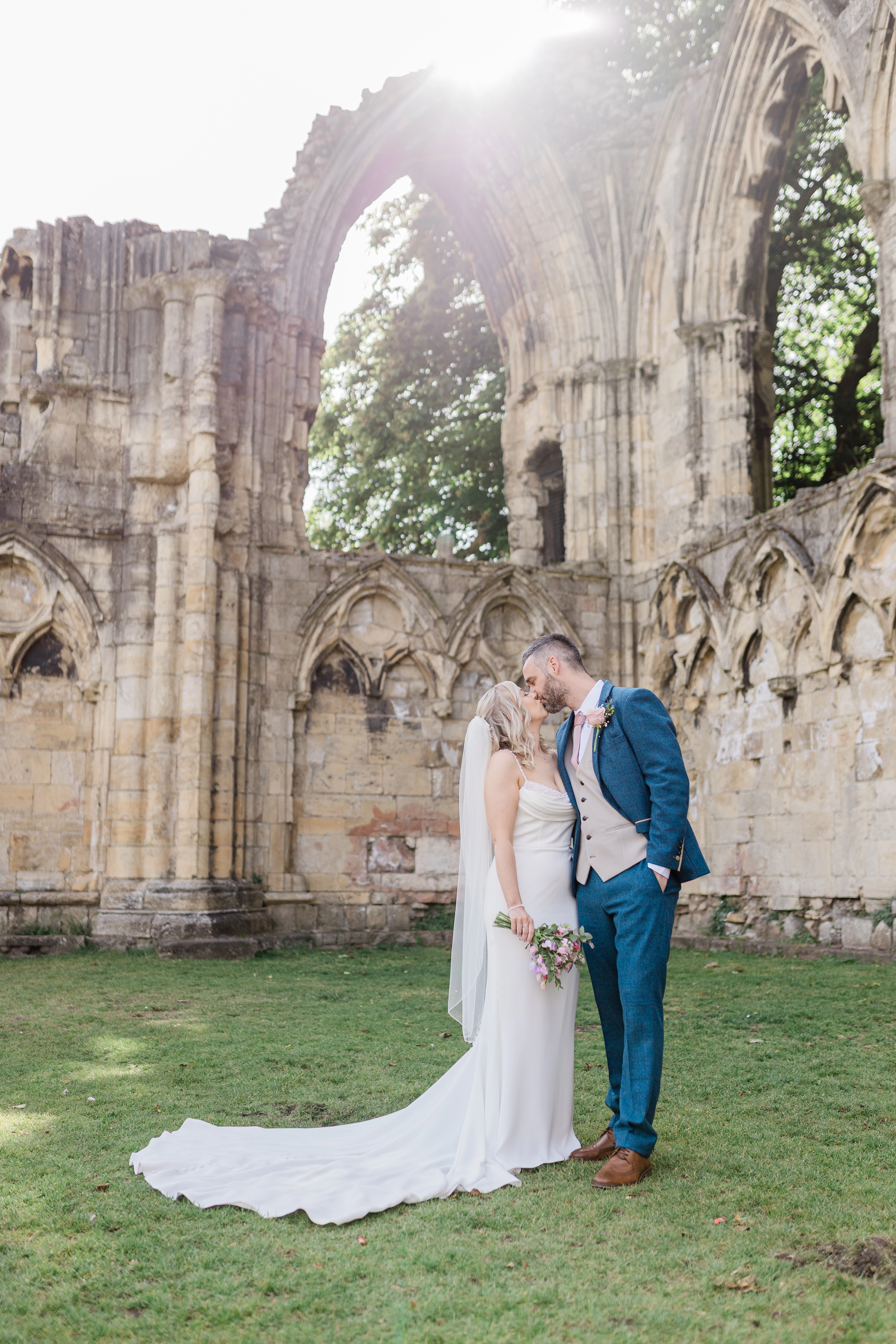the bride and groom kissing within the old ruins in the grounds of The Hospitium, York