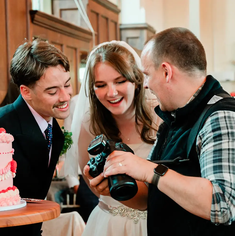 Andrew Cockerill with a happy couple looking through their photos