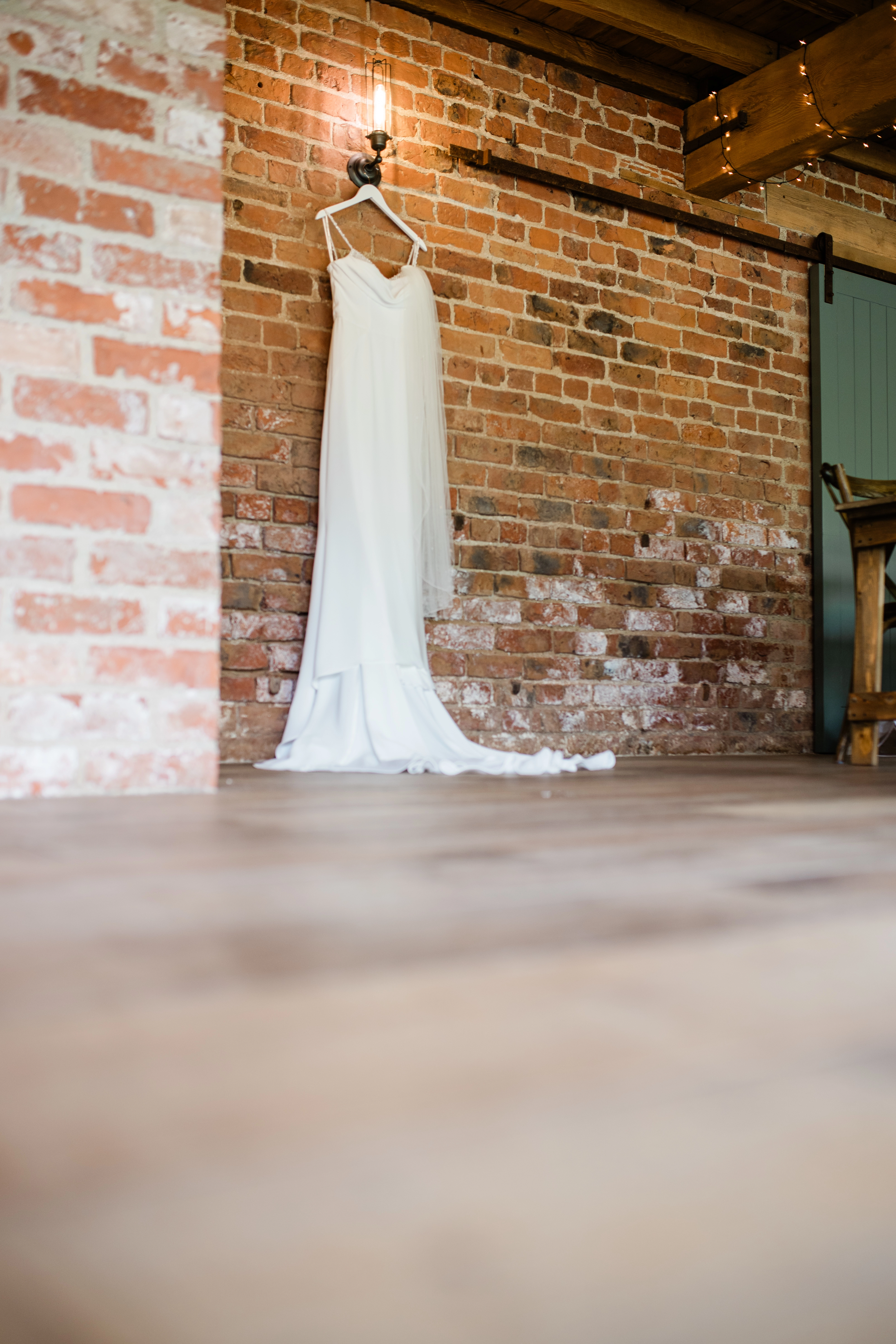 Wedding dress hanging on a brick wall
