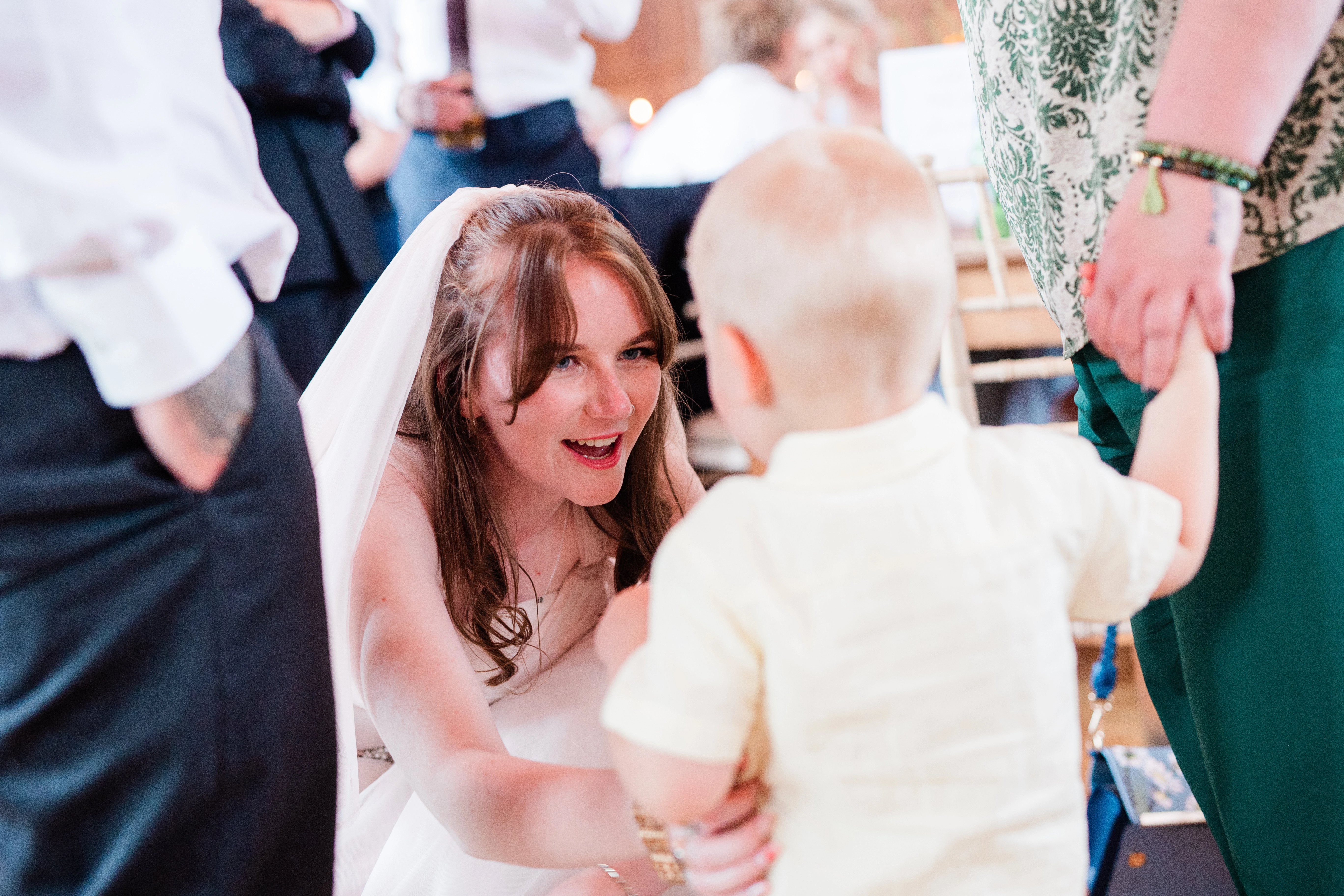 The bride down at a childs level talking to them